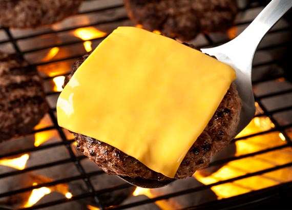 A grilled burger topped with melted cheese