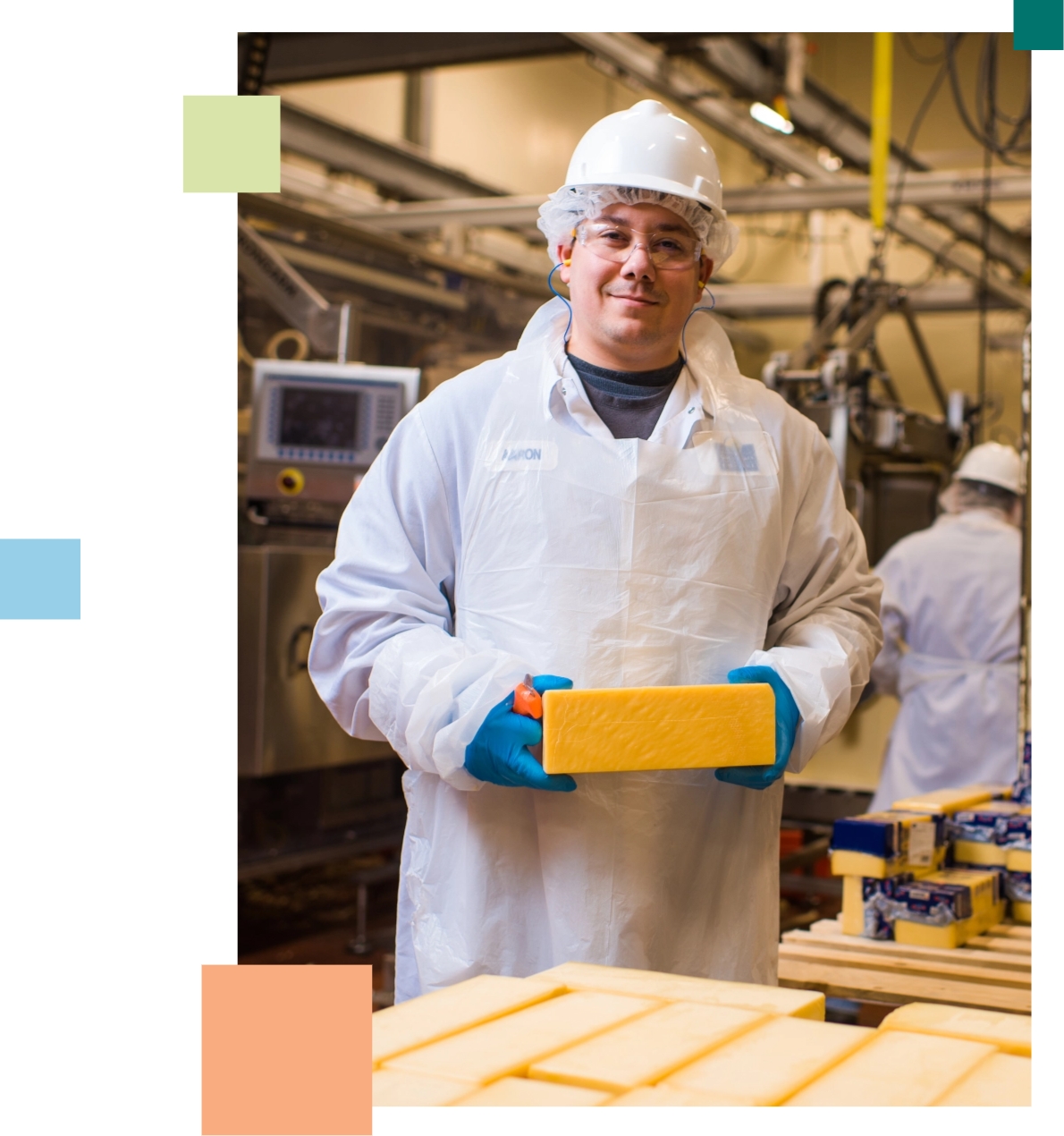 Smiling employee holding a block of cheese