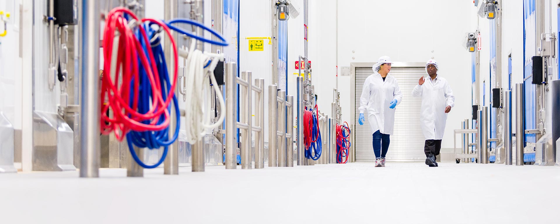 Two employees walking through a factory