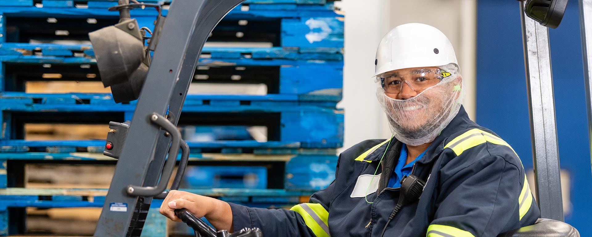 Smiling employee driving a forklift