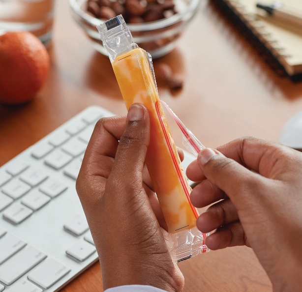 Man eating string cheese at his desk