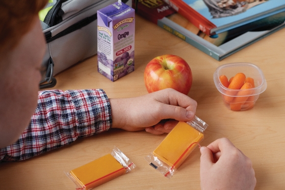 Man eating cheese, apples, and carrots at his desk